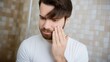 © Road Red Runner - Bearded man closely examines his manicured hand, featuring subtle nail polish, while touching his face indoors