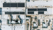 © AmazingAerialAgency - Aerial view of solar panels arrayed on a vast, flat rooftop, juxtaposed against the stark geometry of ventilation systems, Becej, Vojvodina, Serbia.