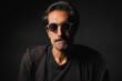 © Heart in pictures - Stylish man with sunglasses poses against a dark background