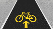 © Umi - A white bicycle symbol painted on the asphalt street defines a dedicated urban bike lane for safe transportation and cycling traffic along the city road way