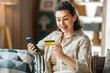 © Konstantin Yuganov - Happy Woman Shopping Online With Credit Card and Smartphone at H