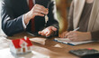 © Konstantin Yuganov - Closeup of Real Estate Agent Handing House Keys to Client During Home Purchase Agreement Signing