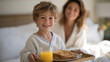 © AnastasiiaRozhmanova - Young child in pajamas serves burnt toast and orange juice on tray to mother still in bed on Mother's Day morning, proud grin, soft morning light through curtains, breakfast in bed childhood effort