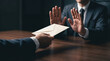 © Monktwins - Politician or businessman refusing bribe envelope at meeting table, anti corruption and bribery concept.