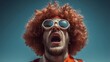 © Mateusz - Man with an orange afro and sunglasses screaming against the blue sky
