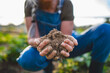 © Halfpoint - Close up of female famer hands holding soil outdoors at community farm.