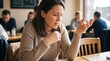 © Tina - A young Caucasian woman with brown hair sits at a wooden table in a cafe, looking thoughtful. People are visible in the background, engaged in conversation.