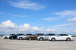 © Md Ikbal - Row of different colored cars parked on a concrete surface under blue sky