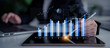 © InfiniteFlow - A business professional is using a tablet to analyze financial data displayed through interactive graphs and charts, illustrating market trends and success. Scalp