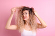 © New Africa - Unhappy woman with tangled hair on pink background