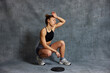 © Javier Díez/Stocksy - Woman exercises with weights in a gym during a workout session