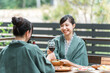 © buritora - Young Asian women on a girls' trip to a ryokan (Japanese inn) or hot spring inn where they dine on a balcony or wooden deck.