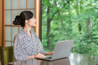 © buritora - A woman in a yukata working on her laptop in a room at a hot spring inn.