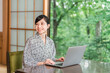 © buritora - A woman in a yukata working on her laptop in a room at a hot spring inn.