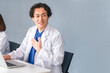 © buritora - A male doctor in a white coat sitting at a desk and working.
