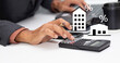 © Surasak Chuaymoo - business man with calculator and calculate interest rate of condo and home, financial mortgage loan calculation, property tax, and investment