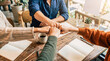 © valerie - Photograph of diverse team members doing a fist bump over a wooden desk, symbolizing collaboration and unity.
