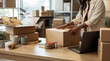 © Christine - Focused woman entrepreneur efficiently packing a large customer order box for her thriving online e-commerce business.