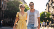© NeuroCake - Happy couple walking on sunny city street. Young man and woman embracing while strolling downtown in summer