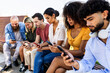 © Xavier Lorenzo - Group of friends using smartphone together and sharing social media. People connected through mobile app interaction, enjoying digital communication in a casual group setting. Technology concept