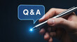 © Zain khan - A hand holding a pen with a glowing blue Q&A speech bubble in the background.