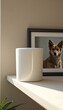 © AlenaSi - 白いコップが窓辺の棚に置かれている。背景には犬の写真がフレームに入って飾られている。居心地の良いインテリアや生活空間のイメージを表現している