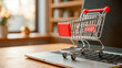 © NikProArt - Small red shopping cart on laptop keyboard for online shopping and e-commerce concept