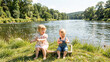 © vefimov - Happy siblings posing together near calm river waters.