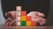 © Dilok - Risk management concept with stacked blocks showing risk levels from low to high, symbolizing business uncertainty, assessment, mitigation strategy and protection planning for sustainable growth
