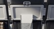 © MdAtiq - A view of an airplane seat pocket containing a blank notebook and pen for travel planning, work, or productivity during a flight in an aircraft cabin