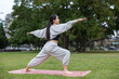 © leungchopan - Woman practicing yoga pose in peaceful park setting