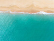 © Timur Abasov - Aerial overhead view capturing the relaxing scene of blue ocean water gently washing onto a golden sand shore. Stock photo