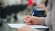 © slexp880 - Woman hand writing on a document with pen during lecture, test or office registration. Paper form completion, education, paperwork and professional training concept. Photo