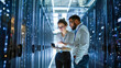 © Aliaksandra - Two IT engineers reviewing server infrastructure on a tablet in a modern data center corridor