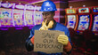 © Krakenimages.com - Man in hardhat holding cardboard sign reading save our democracy and pointing finger in building; labor solidarity determination.