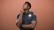 © Krakenimages.com - Man police officer in uniform with hand on chin and crossed arms posing in studio looking upward; thoughtful duty.