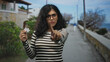 © Krakenimages.com - Woman holding puzzle piece with finger pointing to camera on street promenade by the sea; determination attention.