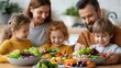 © AZ Studio - Happy family of four enjoying a healthy dinner of fresh vegetables together