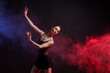 © New Africa - Graceful ballerina practicing dance moves in color lights and smoke against black background. Space for text