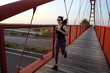 © FotoAndalucia - woman with sunglasses running on a bridge