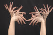 © Pixel-Shot - Stroboscopic photo of moving female hands on dark background