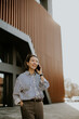 © BGStock72 - Korean woman talking on the phone outside a modern building on a sunny day