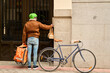 © Oscar - Courier delivering food on bicycle to urban door