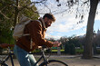 © Oscar - Urban cyclist connecting with smartphone in park