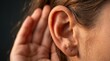© FahVecStudio - Detailed close up of a woman holding her hand behind her ear to listen intently or hearing impairment concept for medical and healthcare themes