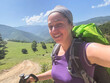 © Юлия Завалишина - Hiking tourism adventure. Backpacker hiker woman taking selfie picture. Hiker girl lady tourist with backpack walking near mountain. Young happy woman enjoy hike trekking tourism active vacation