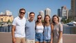 © Bussakon - A group of friends stands together on a promenade enjoying a clear day with a sprawling cityscape view