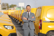 © Ljupco Smokovski - Manager standing in front of a fleet of yellow delivery vans