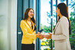 © MIND AND I - Businesswomen Smiling and Shaking Hands at Office