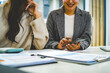 © MIND AND I - Close-Up of Businesswoman Using Smartphone at Office Desk